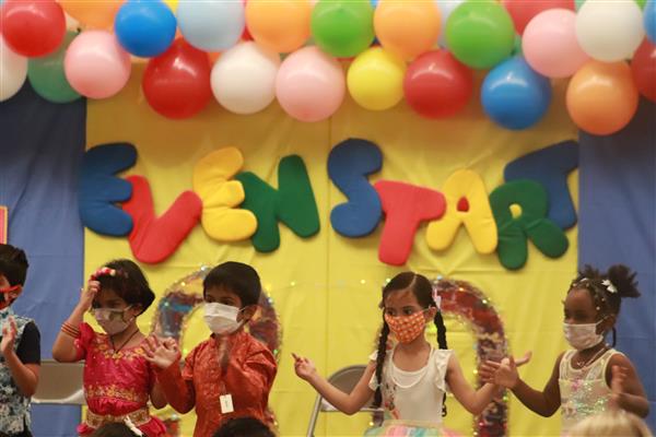 Young students in front of a colorful Even Start sign